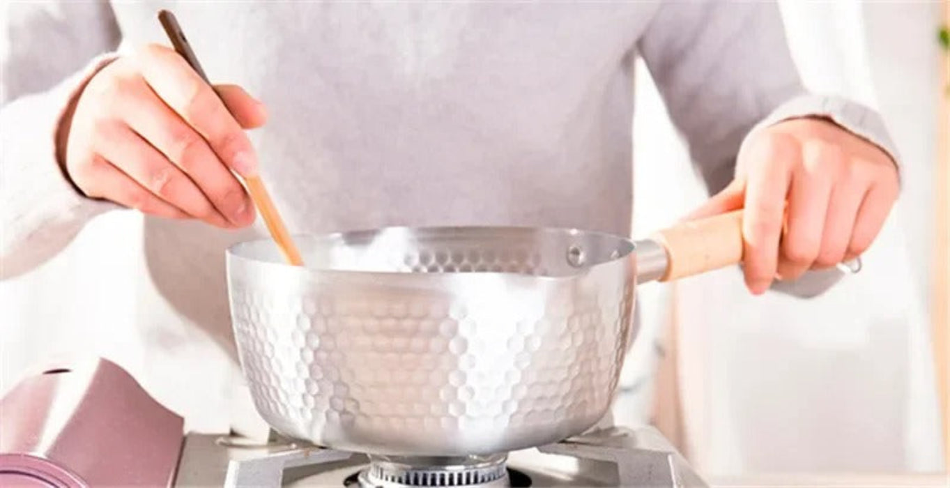 Casserole antiadhésive aluminium en action sur une cuisinière, compatible induction et gaz
