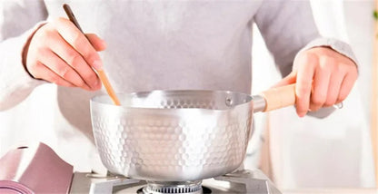Casserole antiadhésive aluminium en action sur une cuisinière, compatible induction et gaz