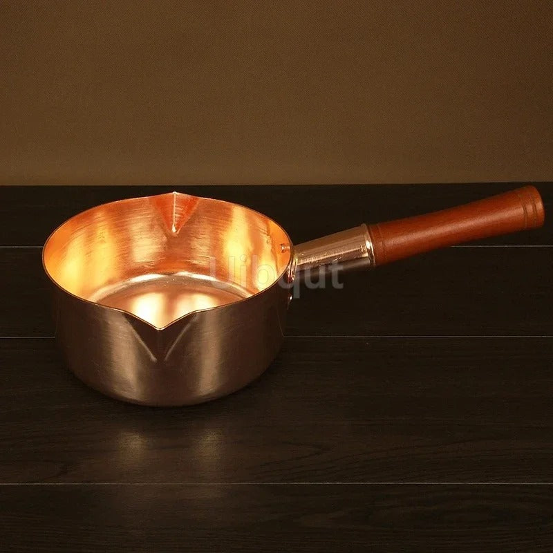Casserole en cuivre avec manche en bois – L’élégance artisanale au service des cuissons précises sur fond neutre