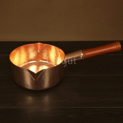 Casserole en cuivre avec manche en bois – L’élégance artisanale au service des cuissons précises sur fond neutre