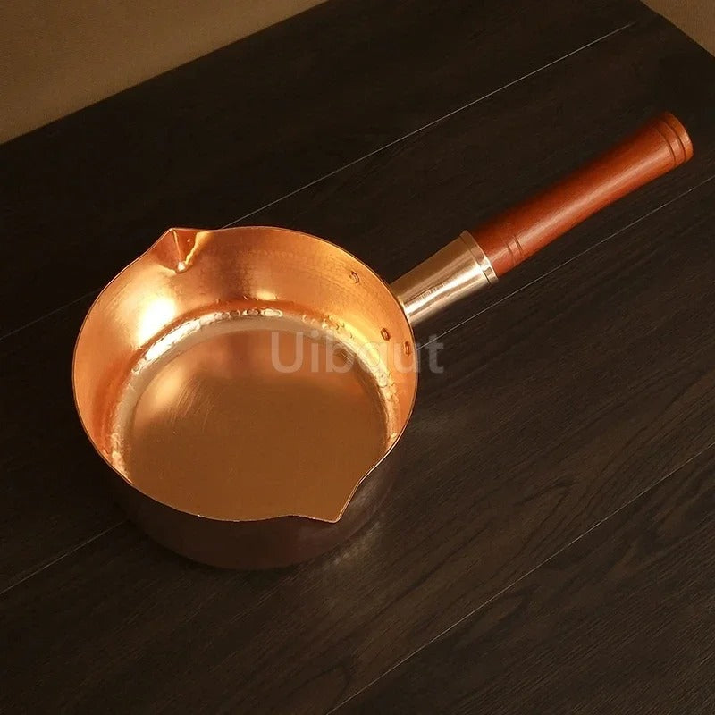 Casserole en cuivre avec manche en bois – L’élégance artisanale au service des cuissons précises sur fond noir