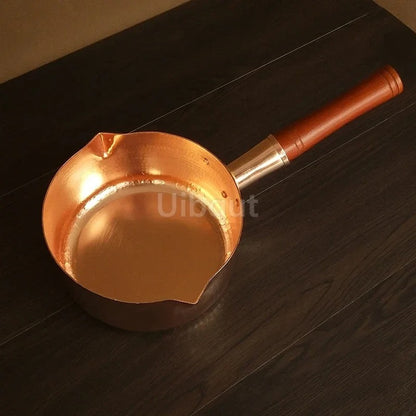 Casserole en cuivre avec manche en bois – L’élégance artisanale au service des cuissons précises sur fond noir