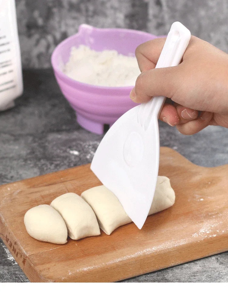 Coupe-Pâte & Racloir à Pâte en action pour couper et rassembler la pâte sur une planche en bois