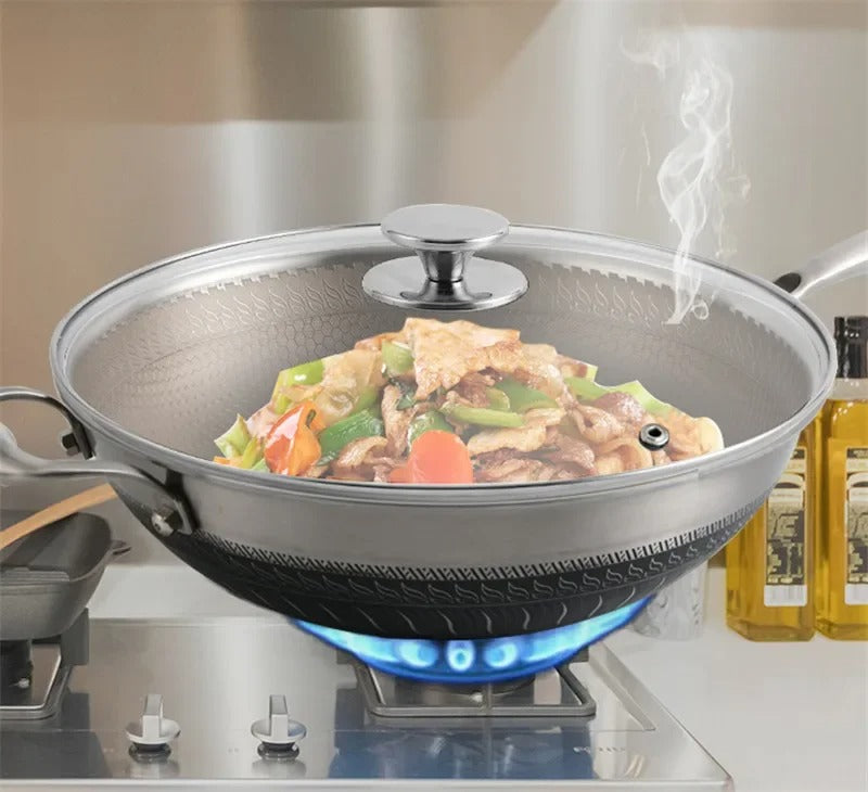 Couvercle universel inox avec poignée verre pour poêle sur une cuisinière avec des légumes cuisinés