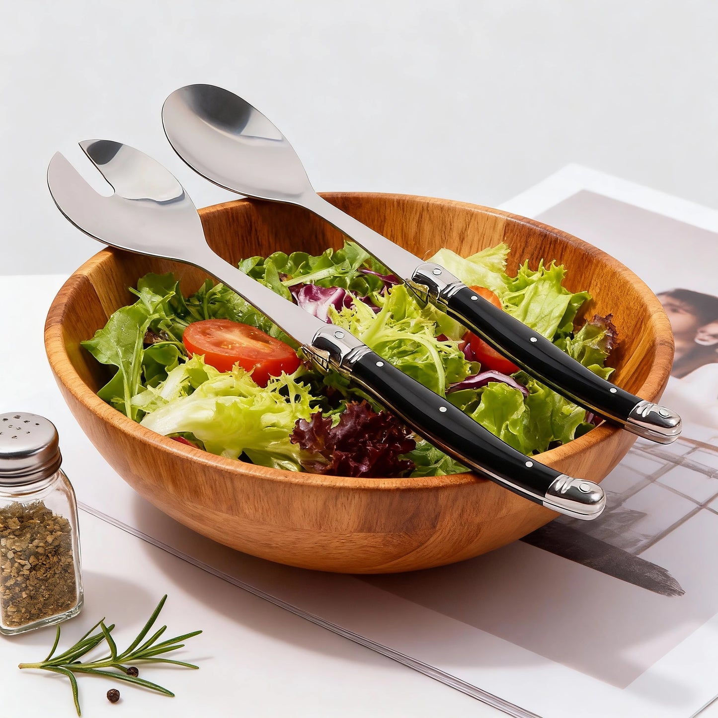 Cuillère à salade inox Lot de 2 serveurs style Laguiole élégants posée sur un saladier en bois avec salade fraîche