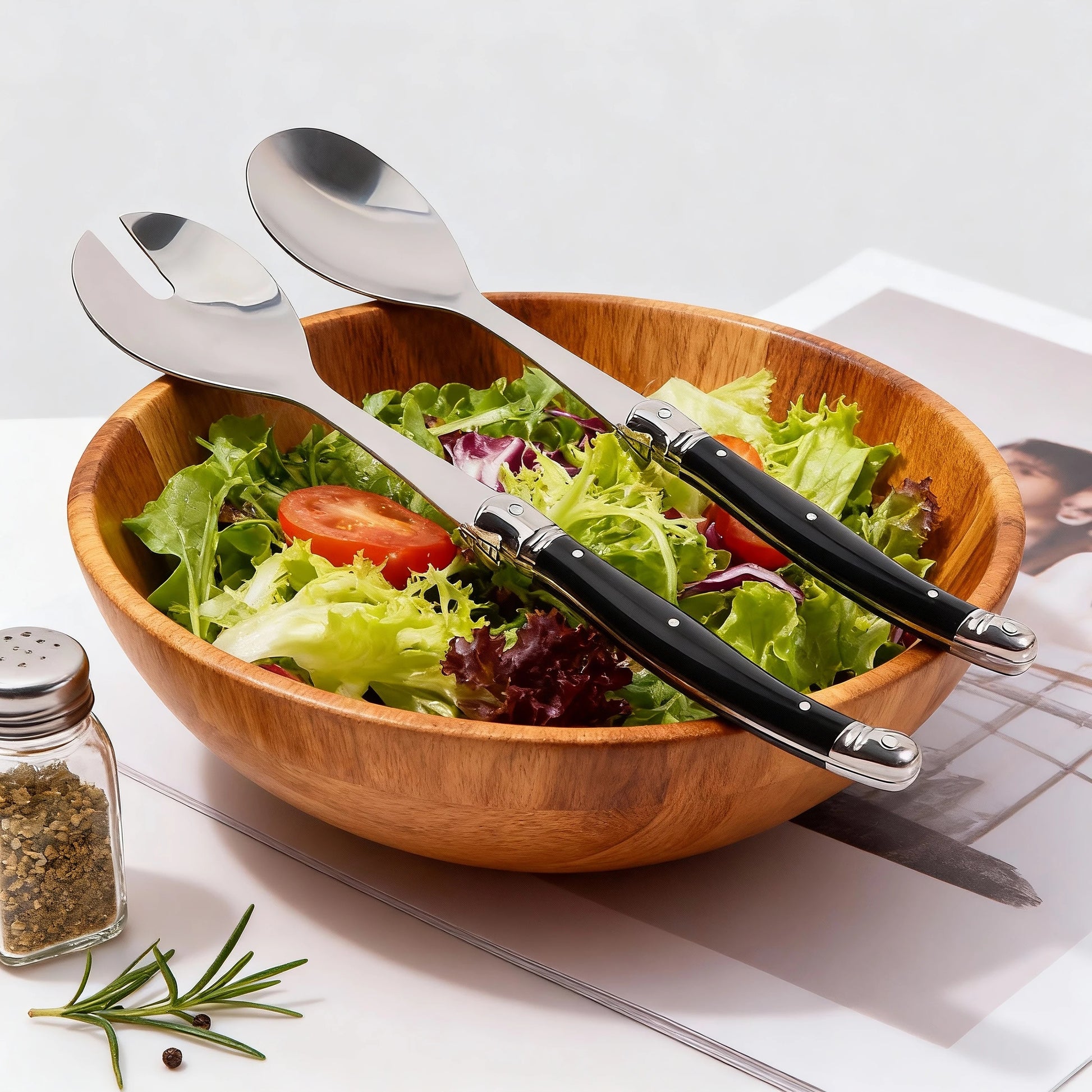 Cuillère à salade inox Lot de 2 serveurs style Laguiole élégants posée sur un saladier en bois avec salade fraîche