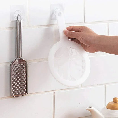 Main tenant une passoire blanche accrochée au mur près d'une râpe Passoire fine nylon & PP – Filtration précise et durable.