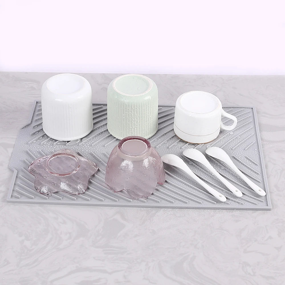 Tapis Égouttoir Silicone Multifonction gris avec tasses bols et cuillères blanches retournées pour séchage