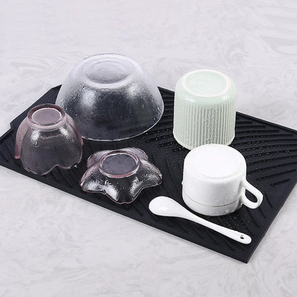Tapis Égouttoir Silicone Multifonction noir avec bols et tasses retournés, gouttes d'eau visibles pour séchage