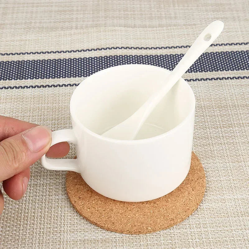 Dessous de Verre en Liège Naturel sous une tasse blanche avec une cuillère en céramique