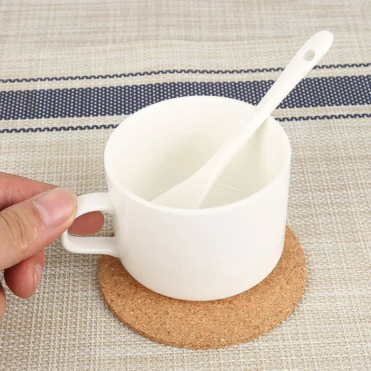 Dessous de Verre en Liège Naturel sous une tasse blanche avec une cuillère en céramique