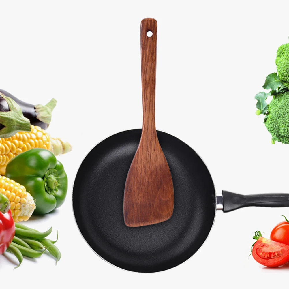 Ustensile de chef Spatule en Bois Cuisine – Durable & Antiadhésive. Dans une poêle noire avec légumes