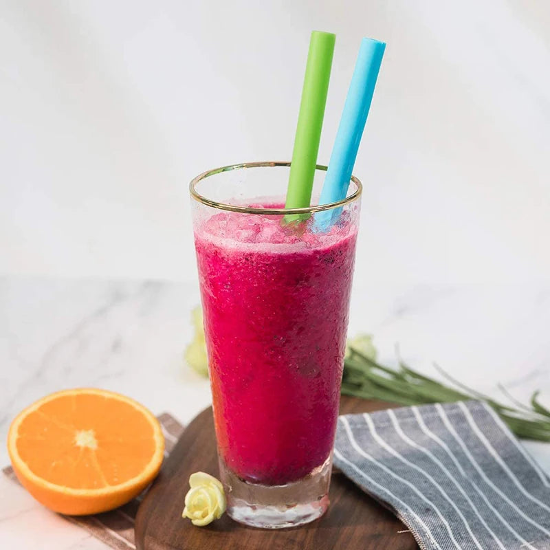 Pailles Réutilisables en Silicone – Lot de 2 avec Brosse insérées dans un smoothie rouge dans un verre haut