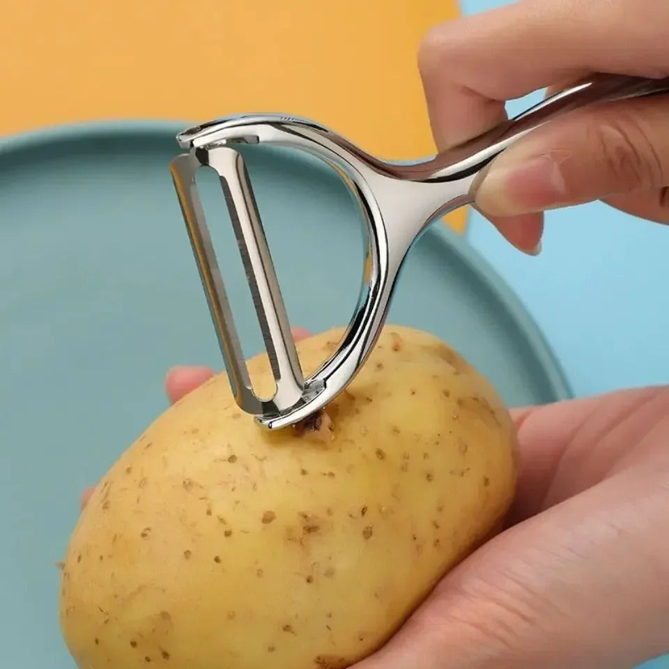 Éplucheur multifonction cuisine pour éplucher et trancher légumes et fruits en utilisation sur une pomme de terre