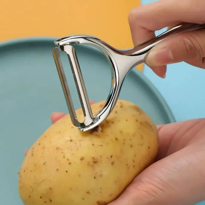 Éplucheur multifonction cuisine pour éplucher et trancher légumes et fruits en utilisation sur une pomme de terre