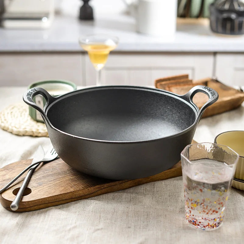 Faitout en Fonte 20 cm Compatible Induction et Tous Feux sur une table en bois avec couverts et verre d'eau