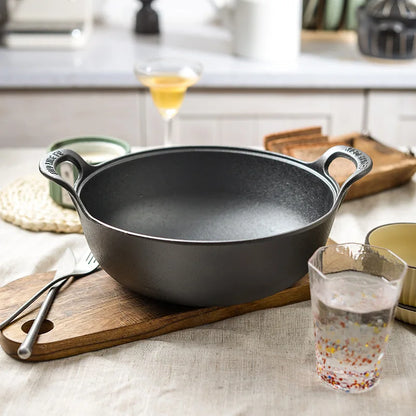 Faitout en Fonte 20 cm Compatible Induction et Tous Feux sur une table en bois avec couverts et verre d'eau