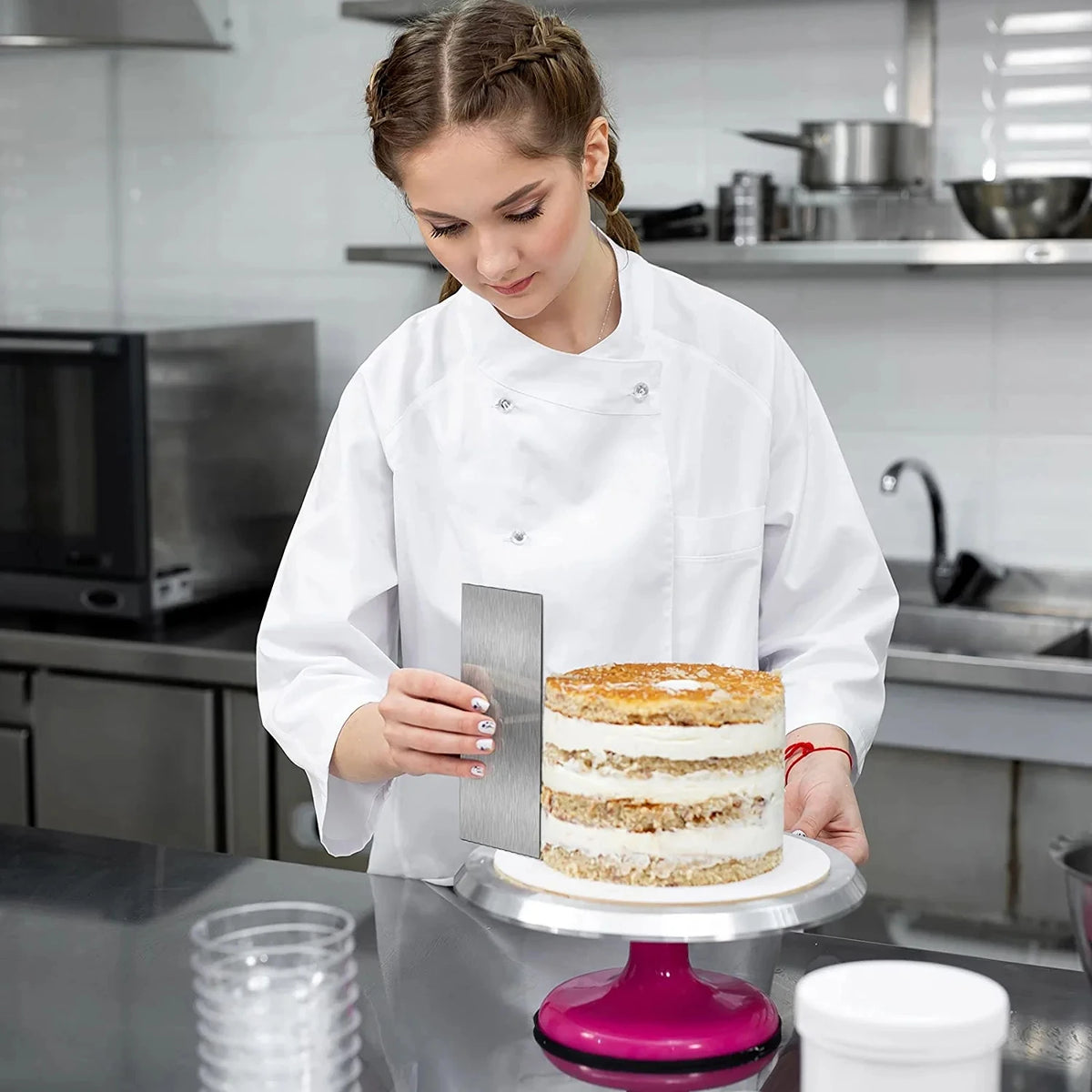 Femme utilisant un Grattoir à Gâteau en Inox pour Décoration sur un gâteau à plusieurs étages en cuisine
