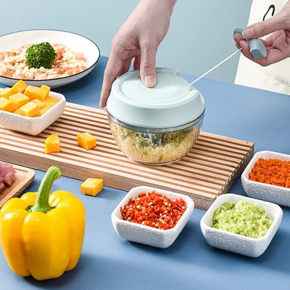 Hachoir Manuel à Corde pour Légumes, Viande et Repas Bébé avec plusieurs ingrédients frais sur la table