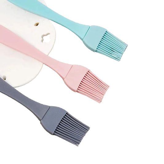 Trois pinceaux de cuisine en silicone dans des couleurs pastel, idéaux pour la cuisson et la pâtisserie.