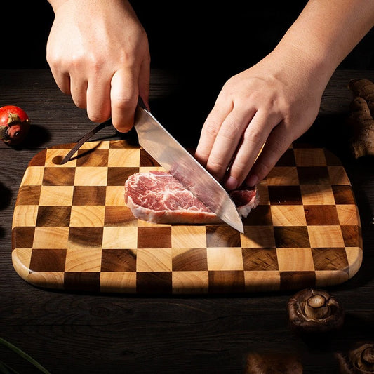 Planche à découper damier en bois d'acacia massif utilisée pour trancher de la viande avec un couteau