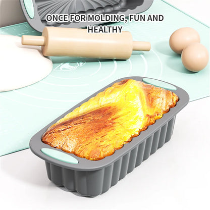 Moule à cake silicone anti-adhésif démoulage facile avec un gâteau doré fraîchement cuit et un rouleau à pâtisserie