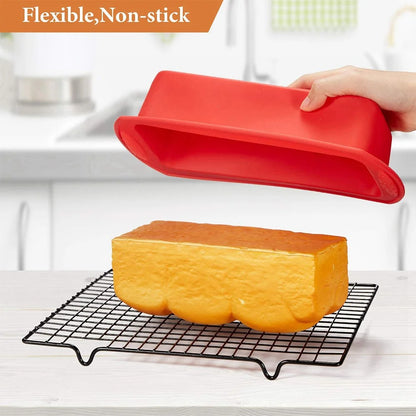 Moule à cake silicone flexible en rouge avec un gâteau bien doré sur une grille de refroidissement