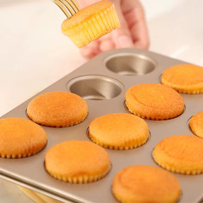 Moule à Muffins Acier Carbone montrant des muffins dorés en cours de démoulage