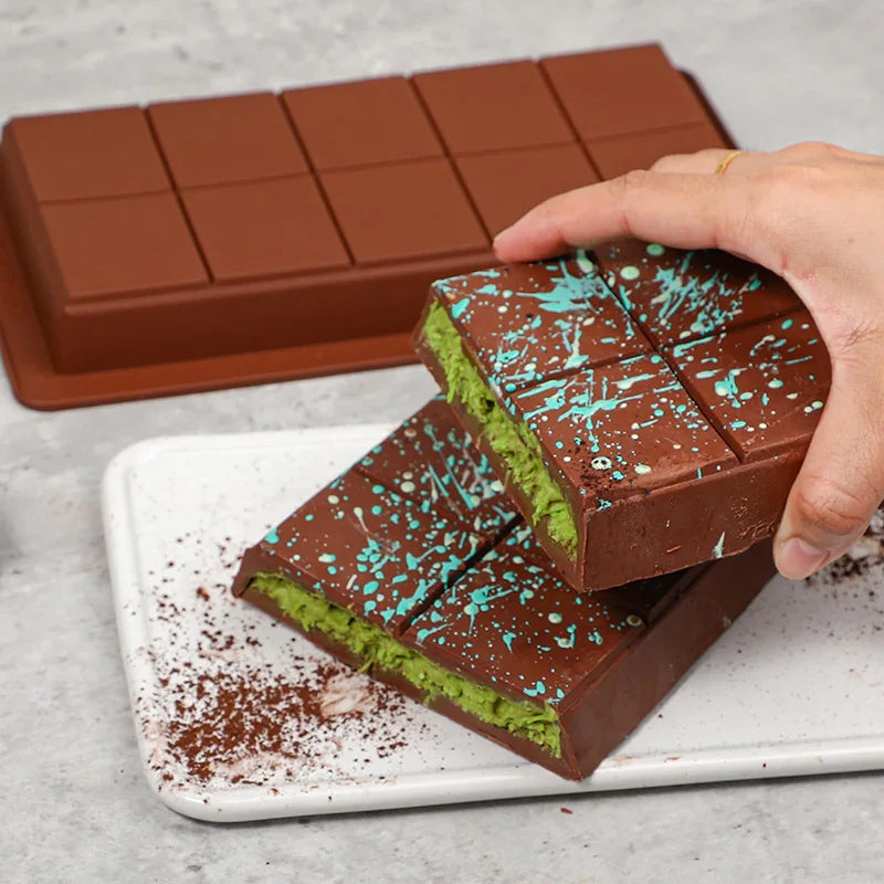 Moule pour faire ses propres tablettes de chocolat avec chocolat vert et bleu décoratif sur un plateau
