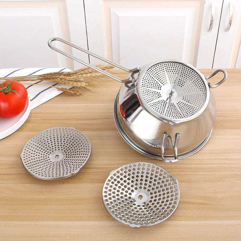 Moulin à légumes à manivelle en acier inoxydable avec accessoires sur un plan de travail de cuisine