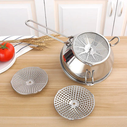 Moulin à légumes à manivelle en acier inoxydable avec accessoires sur un plan de travail de cuisine