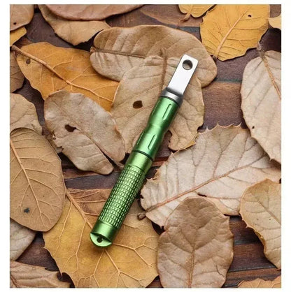 Outil multifonction vert sur des feuilles sèches, parfait pour le Pack de Survie 72h – Kit d’Urgence Complet pour Famille de 3 à 4 Personnes.
