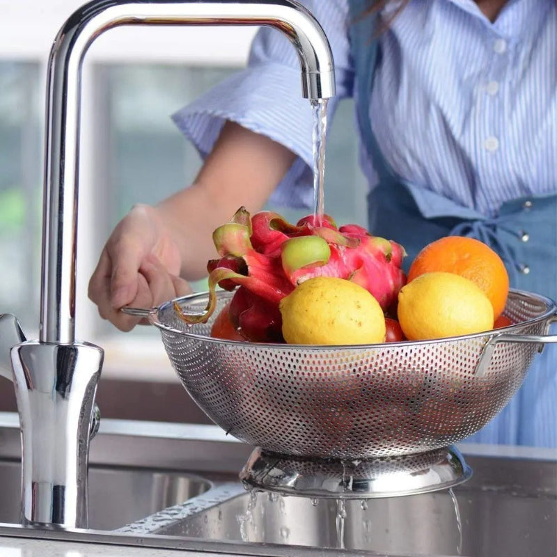 Passoire Inox Microperforée 22,5 cm à Deux Anses avec fruits colorés sous un robinet d'eau