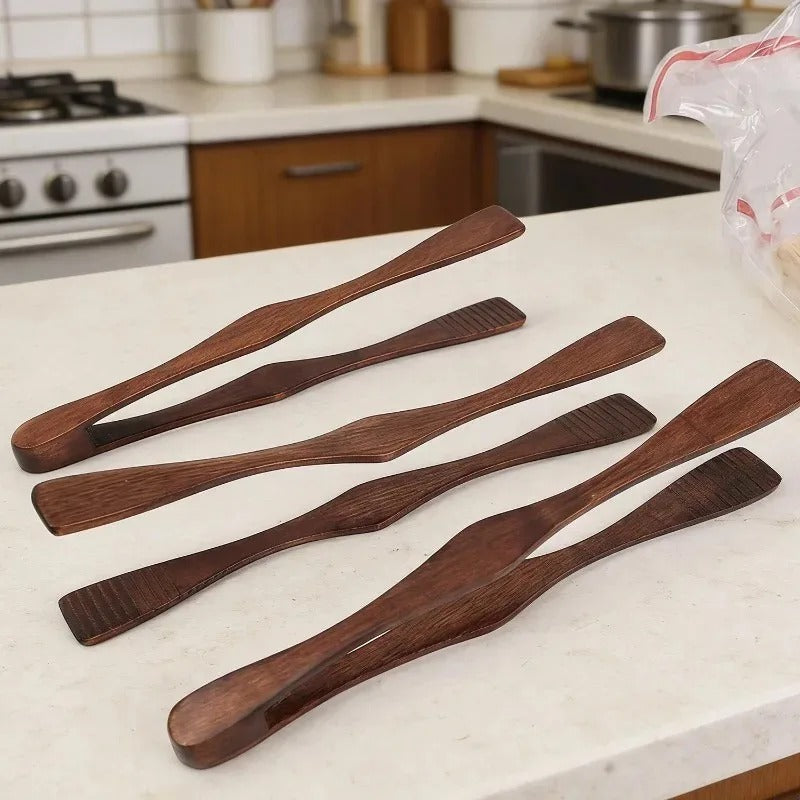 Pince alimentaire en bois 27 cm multifonction en bois sur un plan de travail de cuisine