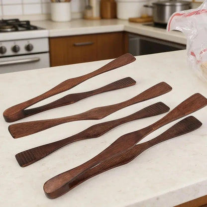 Pince alimentaire en bois 27 cm multifonction en bois sur un plan de travail de cuisine