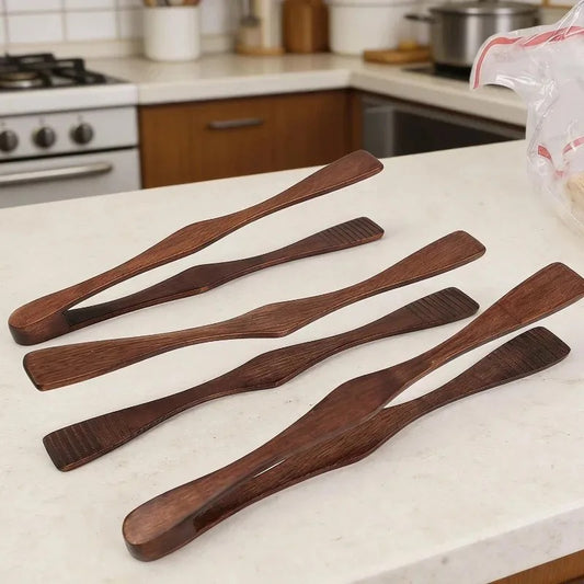 Pince alimentaire en bois 27 cm multifonction en bois sur un plan de travail de cuisine