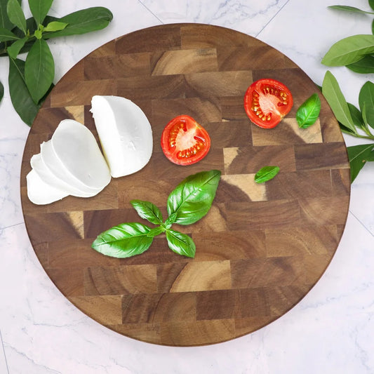 Planche à découper ronde en bois d’acacia massif avec tomates et mozzarella, bilat de cuisine durable