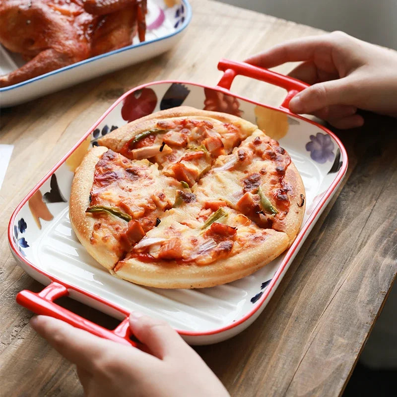 Plat de cuisson en céramique rectangulaire avec des poignées rouges, idéal pour servir des pizzas délicieuses