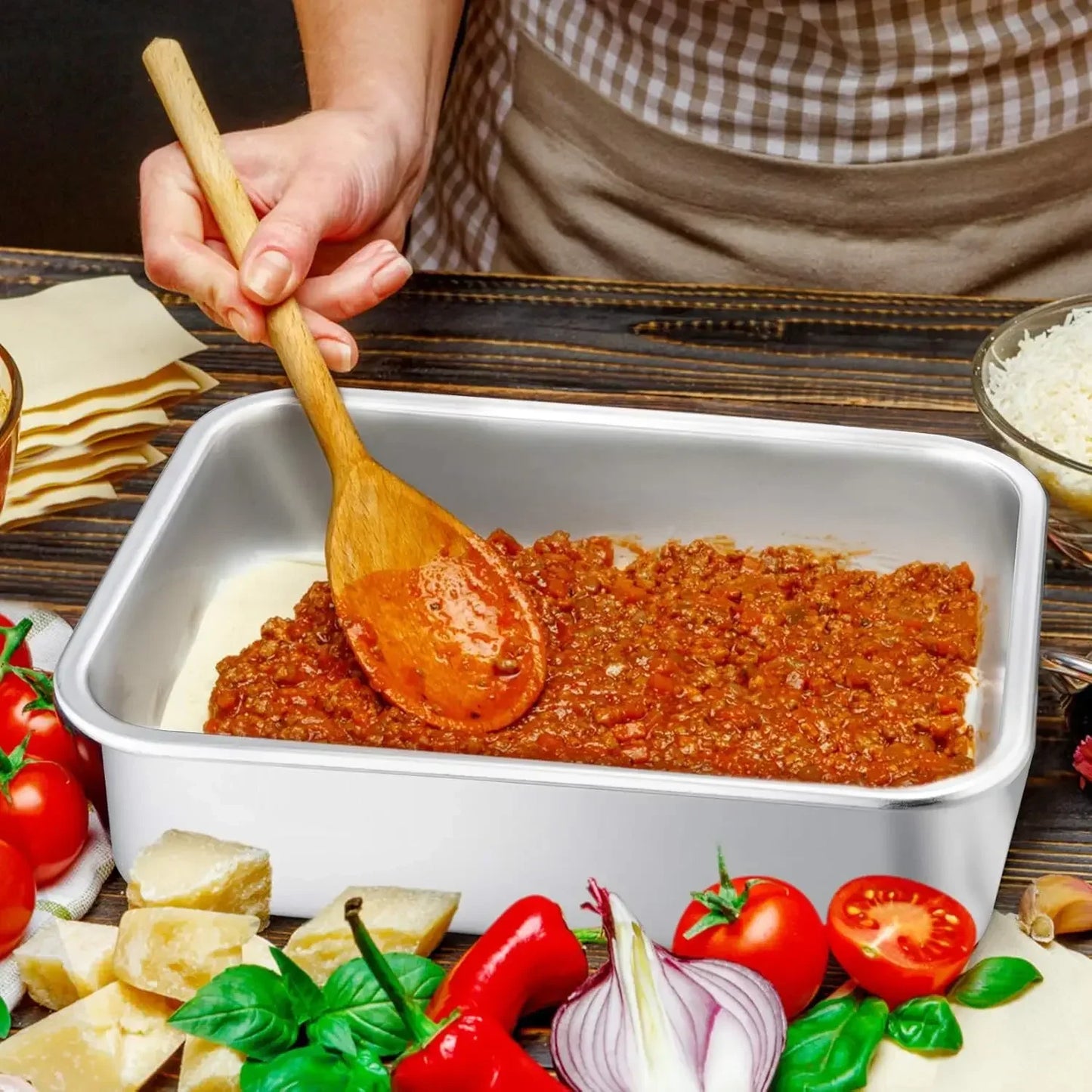 Personne utilisant un Plateau de Cuisson Profond Inox 10 cm – Robuste & Polyvalent pour préparer une sauce bolognaise
