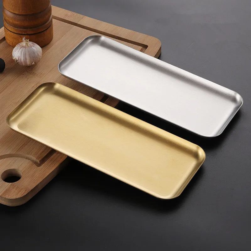 Plateau Inox Multi-Usage – 4 Tailles – Pratique & Durable en inox argenté et doré posés sur une planche à découper en bois