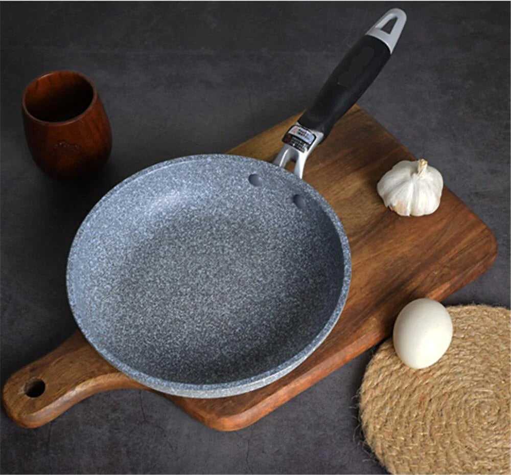 Poêle Wok Antiadhésive pour Plaque à Induction et Gaz sur une planche en bois avec une gousse d'ail et un œuf