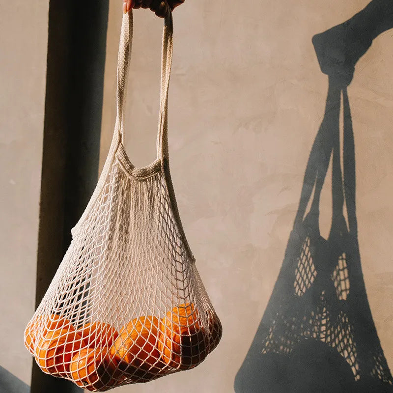 Sac Filet Réutilisable – Tote Bag Coton pour Fruits & Légumes rempli d'oranges sur fond sobre