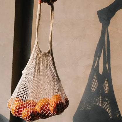 Sac Filet Réutilisable – Tote Bag Coton pour Fruits & Légumes rempli d'oranges sur fond sobre