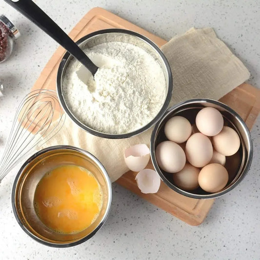Ustensile de chef Saladier Inox avec Couvercle Antidérapant sur une planche en bois avec des ingrédients de cuisine