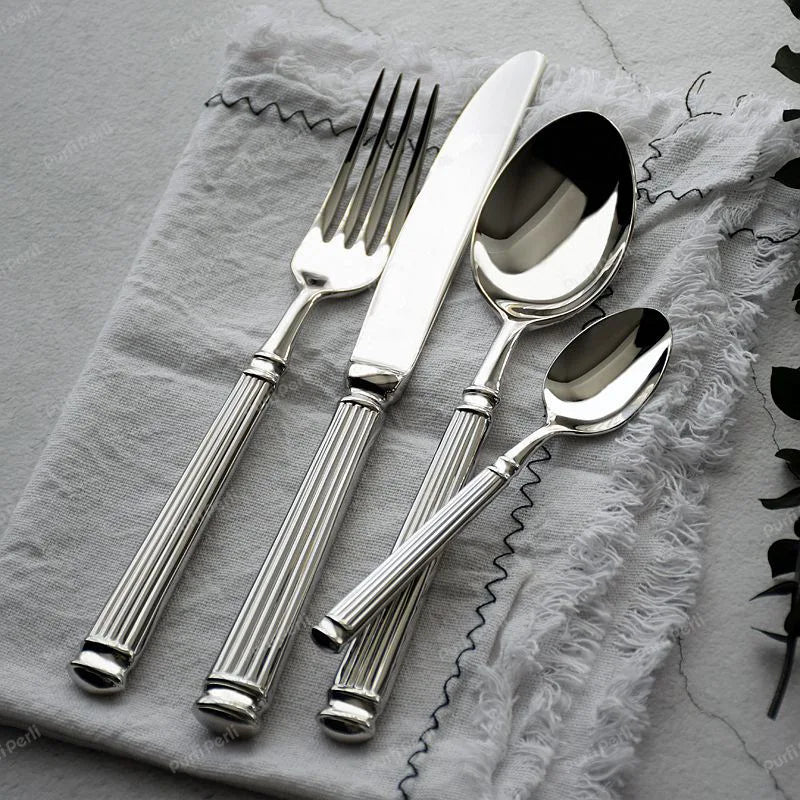Service de couverts inox gravés – Set cuillère fourchette couteau sur une nappe en lin