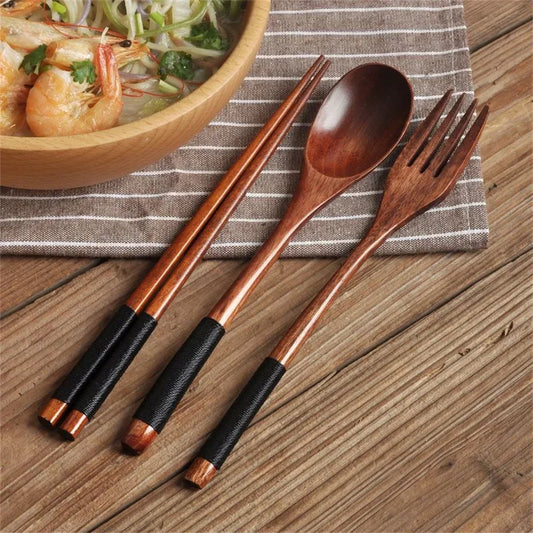 Set de Couverts en Bois 3 Pièces – Cuillère, Fourchette, Baguettes sur une nappe en lin avec un bol de nouilles
