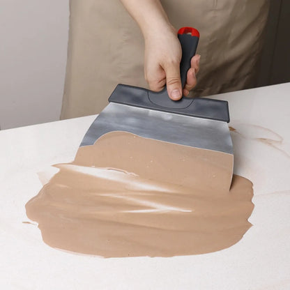 Ustensile de chef en action avec une spatule à tremper et à étaler le chocolat en inox sur une surface de travail