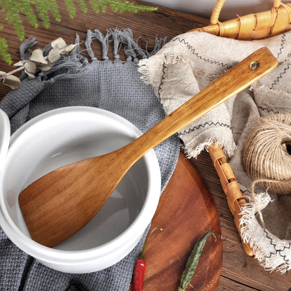 Spatule en Bois Naturel pour Poêle Antiadhésive sur un fond de cuisine chaleureuse avec des accessoires