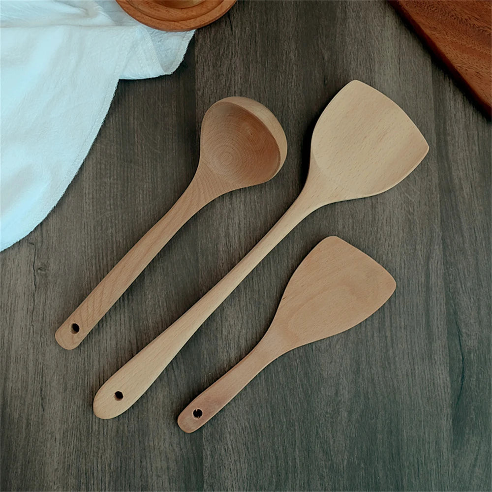 Spatule en Bois Naturel – Ustensile Sain Anti-rayures posée sur table en bois clair avec autres ustensiles