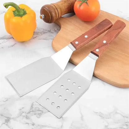 Spatule inox avec manche en bois, parfaite pour la cuisine et le barbecue, présentée avec des légumes frais